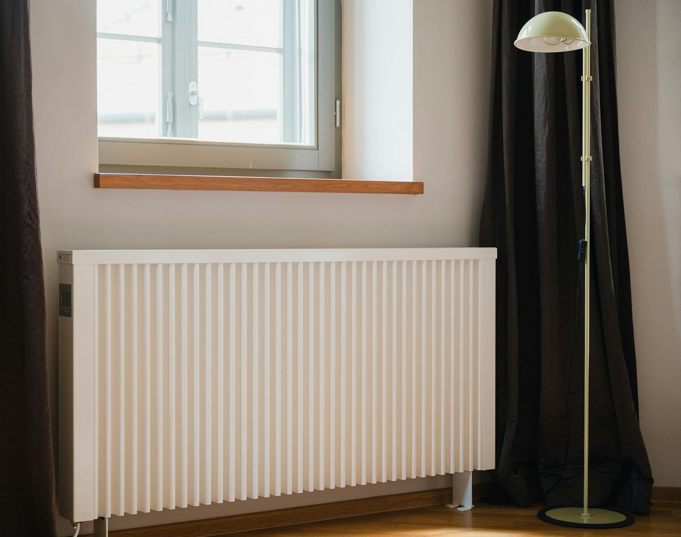 Weißer Heizkörper unter einem Fenster